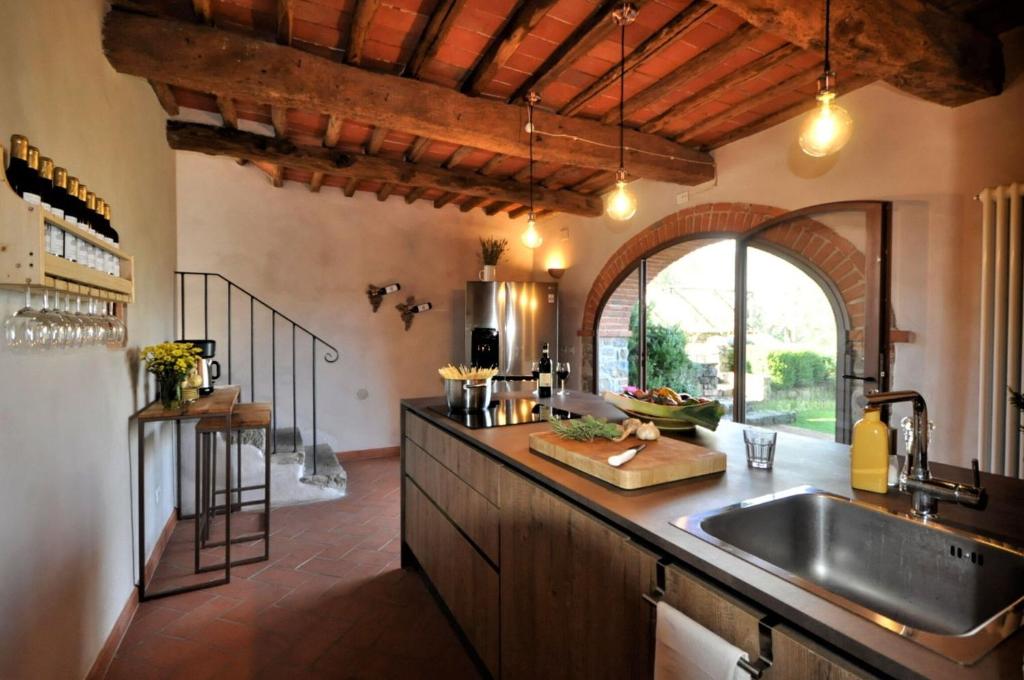 une cuisine avec un évier et une grande fenêtre dans l'établissement Villa Claudia, à Cavriglia