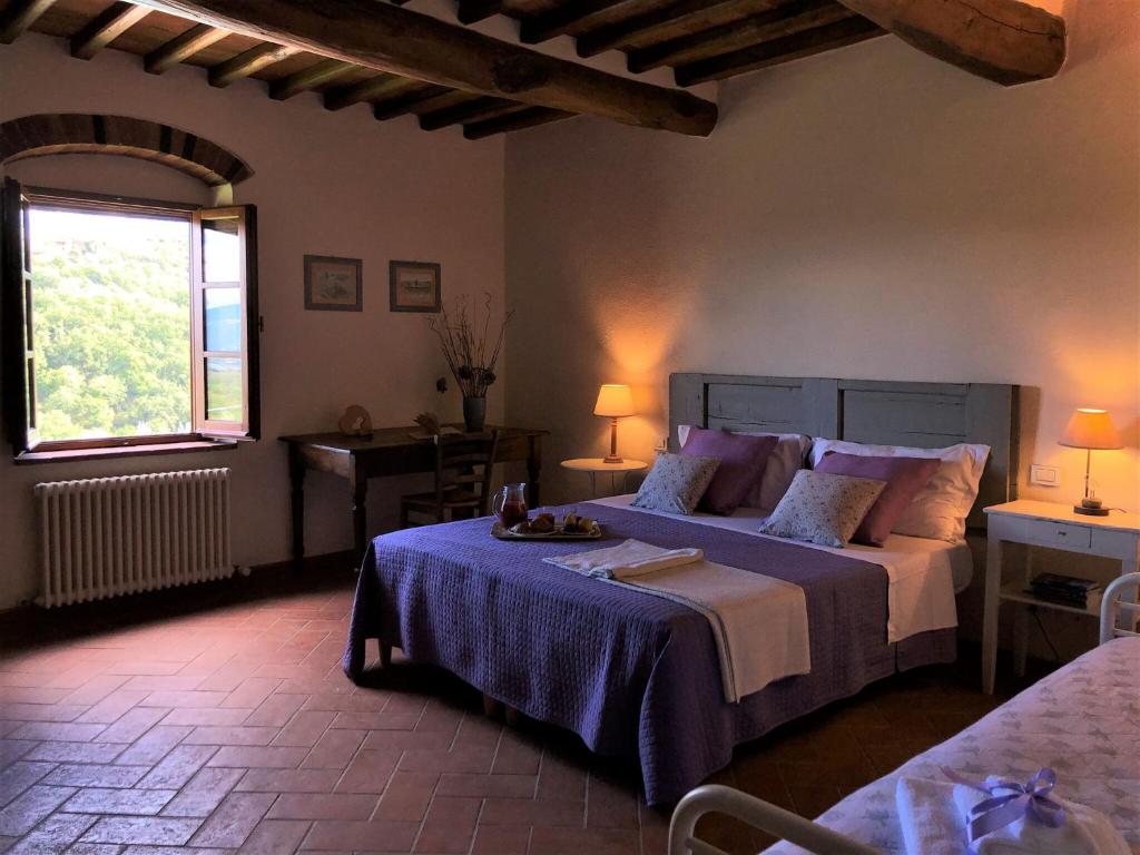 une chambre avec un grand lit et une fenêtre dans l'établissement Villa Claudia, à Cavriglia 34 autres photos