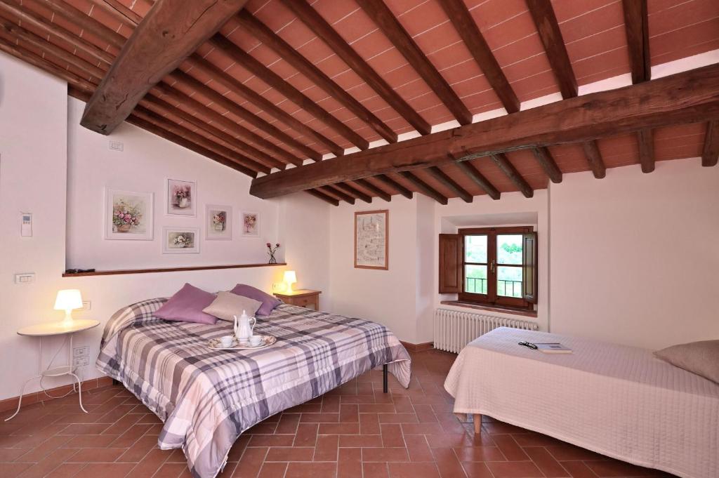 une chambre avec un grand lit et une fenêtre dans l'établissement Villa Claudia, à Cavriglia