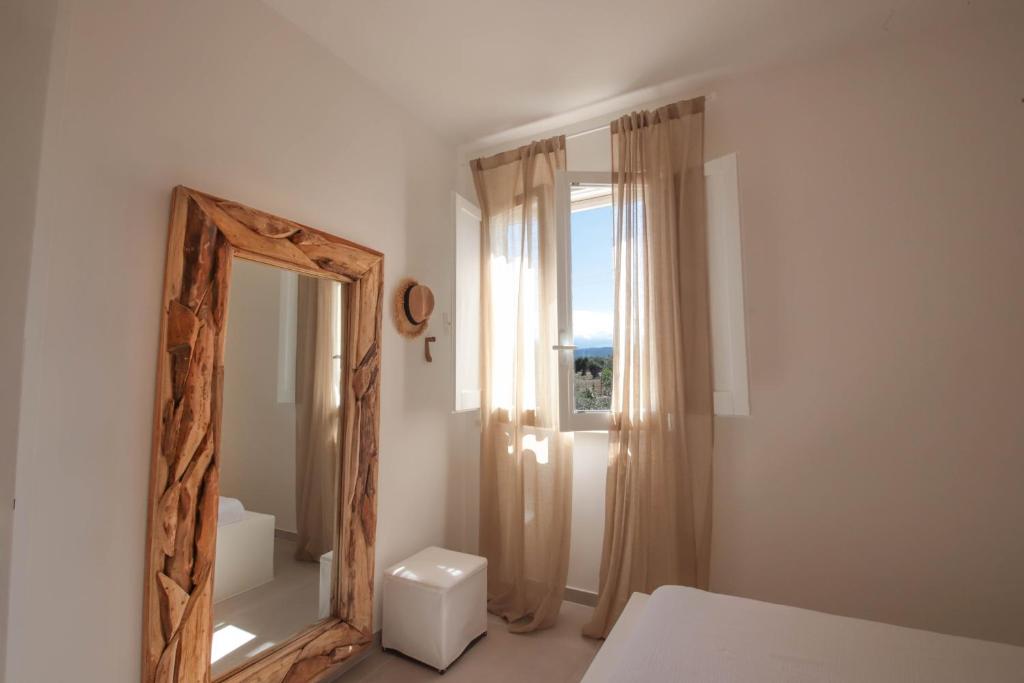 - un miroir dans une chambre blanche avec une fenêtre dans l'établissement Villa con Piscina Dimora Egnazia, à Monopoli