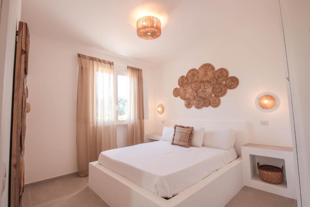 une chambre blanche avec un lit blanc et une fenêtre dans l'établissement Villa con Piscina Dimora Egnazia, à Monopoli