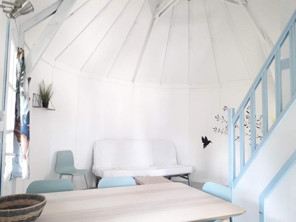 une chambre avec une table, des chaises et des escaliers dans l'établissement Camping le Camarguais, à Lattes