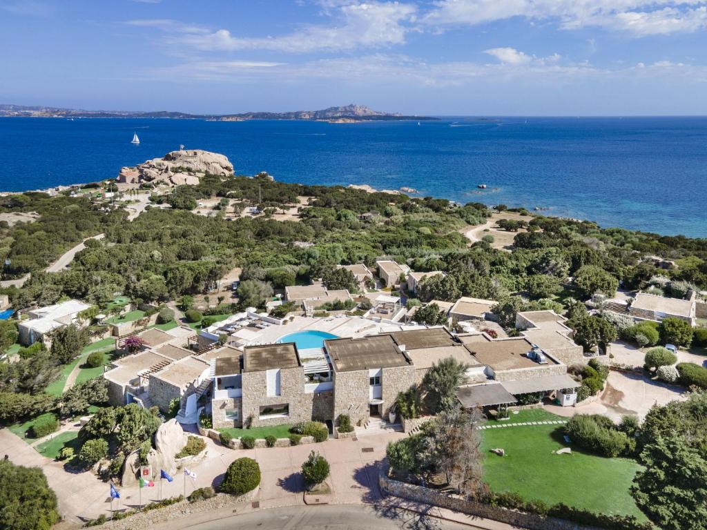 - une vue aérienne sur une maison et l'océan dans l'établissement Hotel Grand Relais Dei Nuraghi, à Baja Sardinia
