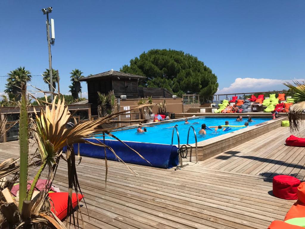 - une piscine dans un complexe avec des personnes dans l'établissement MOBIL HOME PLAGE DE PAMPELONNE SUR UN TRES BEL EMPLACEMENT SURPLOMBANT LA BAIE DE PAMPELONNE, à Saint-Tropez