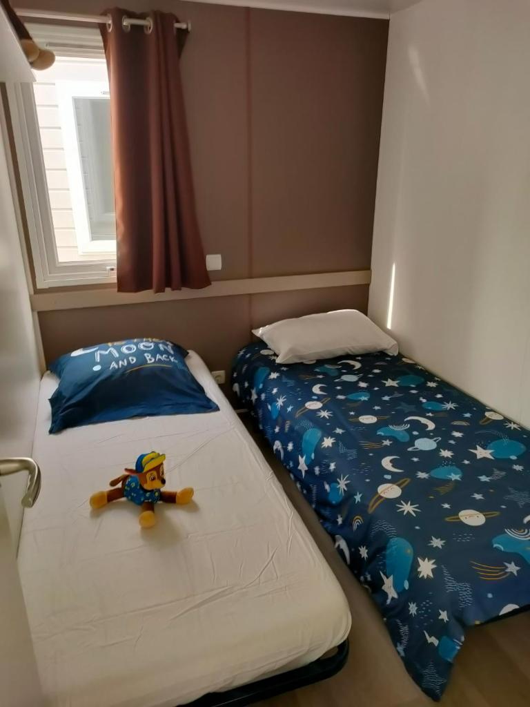 - une chambre lits jumeaux avec un jouet dans l'établissement Mobil-home Siblu Les Rives de Condrieu, à Condrieu