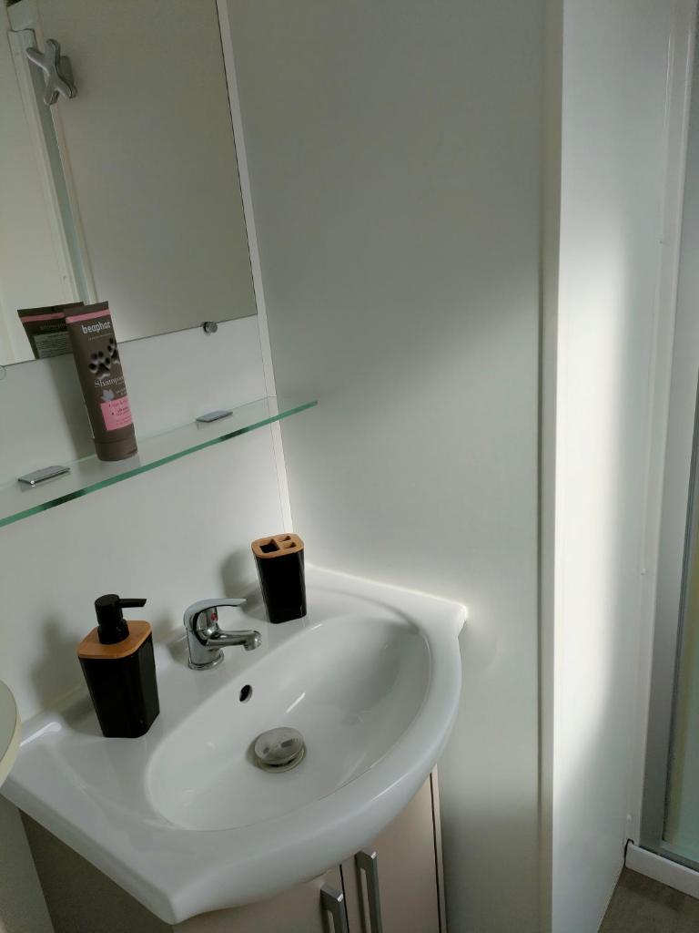 - un lavabo blanc avec deux tasses dans l'établissement Mobil-home Siblu Les Rives de Condrieu, à Condrieu
