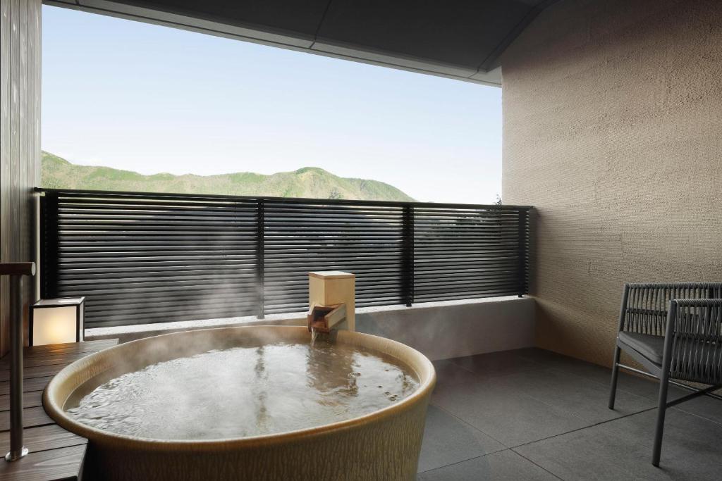 Cette chambre dispose d'une grande fenêtre et d'une grande baignoire. dans l'établissement Laforet Hakone Gora Yunosumika, à Hakone
