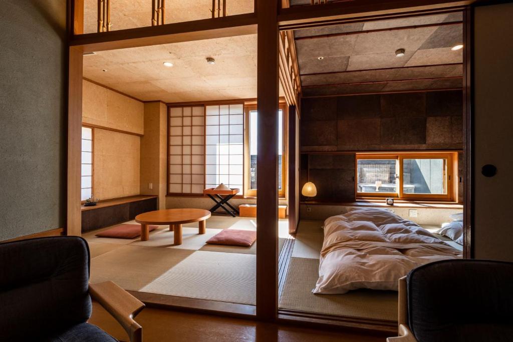 une chambre avec un grand lit et une table dans l'établissement Sanyoan, à Otofuke