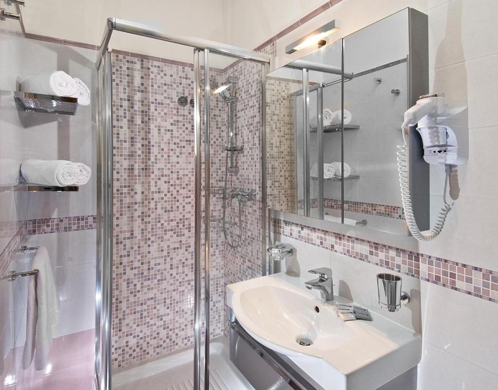 une salle de bain avec un lavabo et une douche dans l'établissement Hotel Europa, à Cupra Marittima