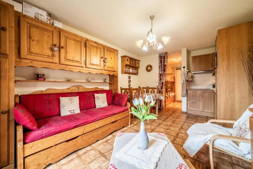 un salon avec un canapé rouge et une table dans l'établissement Morillon - Studio 4 personnes, à Morillon 15 autres photos