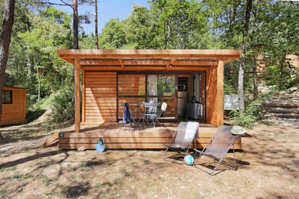 une petite cabine avec deux chaises et une table dans l'établissement Camping La Pinède, à Excenevex