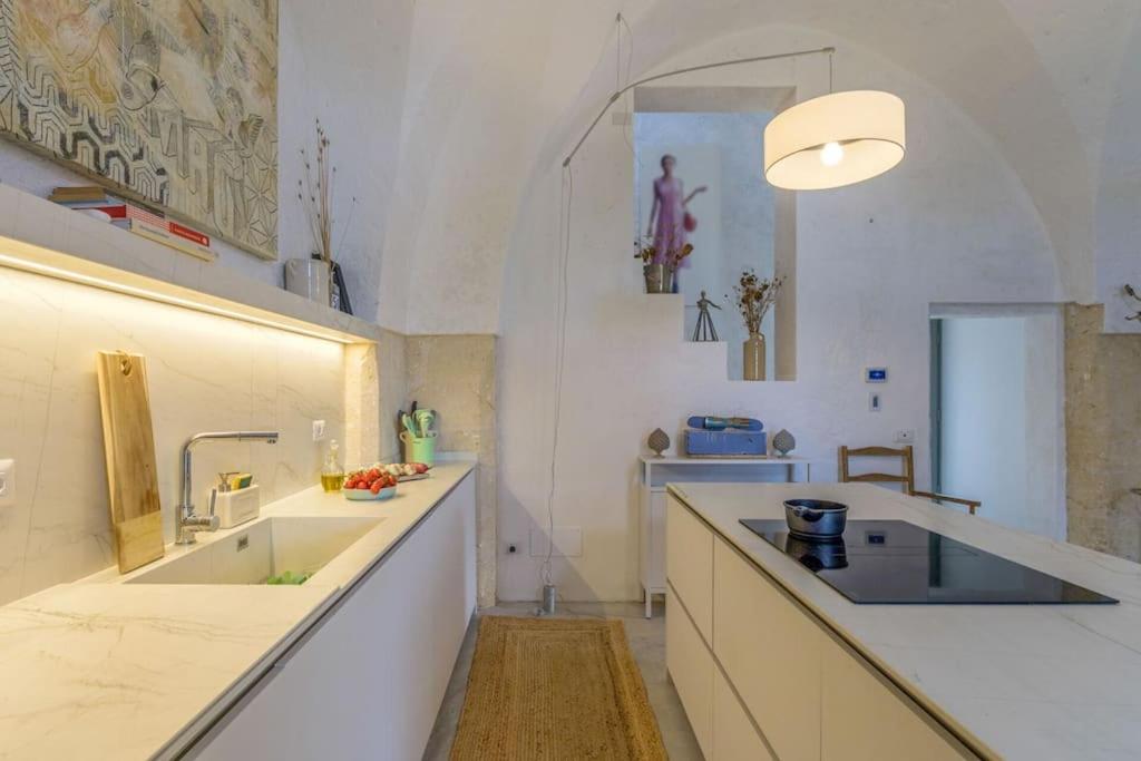 une grande cuisine avec des comptoirs blancs et un évier dans l'établissement Lamia Del Grano by Raro Villas, à San Vito dei Normanni 82 autres photos