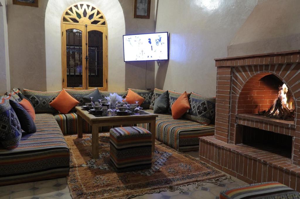 un salon avec un canapé et une cheminée dans l'établissement Riad Dar Susan - Authentic Stay in Zagora, à Zagora