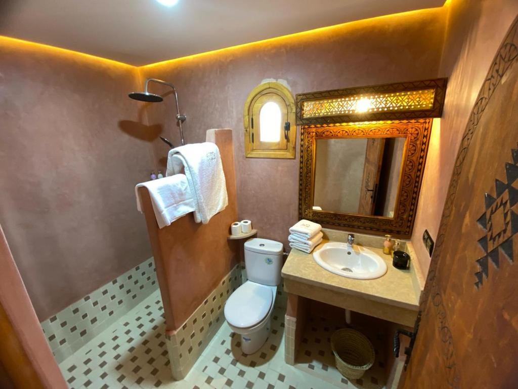 une salle de bain avec toilettes, lavabo et miroir dans l'établissement Riad Dar Susan - Authentic Stay in Zagora, à Zagora