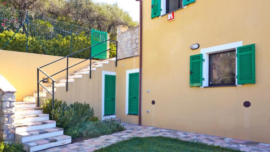 une maison avec des fenêtres et des escaliers à volets verts dans l'établissement Miralunga la Villetta, à Lerici