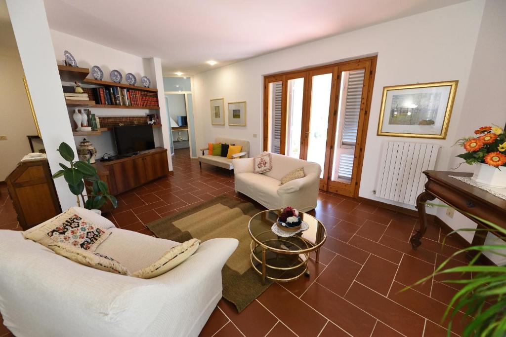 un salon avec deux chaises blanches et une table dans l'établissement Casa Giovanna, à Castelfranco di Sopra