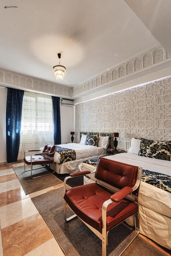 - une chambre avec deux lits, une chaise et un canapé dans l'établissement Ryad A&B Sarai, à Chefchaouen