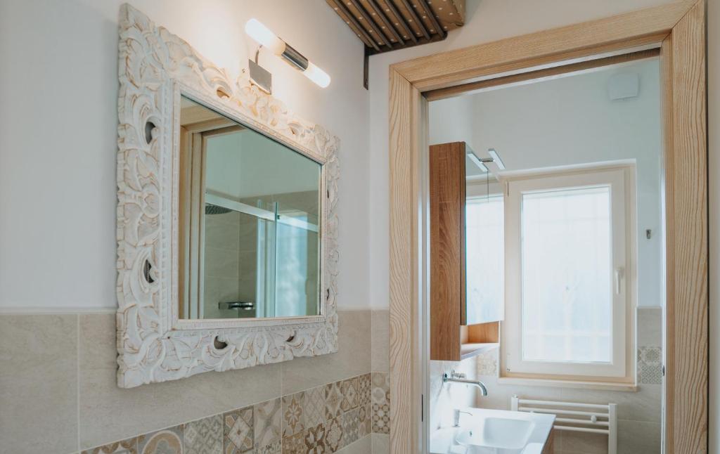 une salle de bain avec un miroir et un lavabo dans l'établissement Trullo del Benessere, à Martina Franca