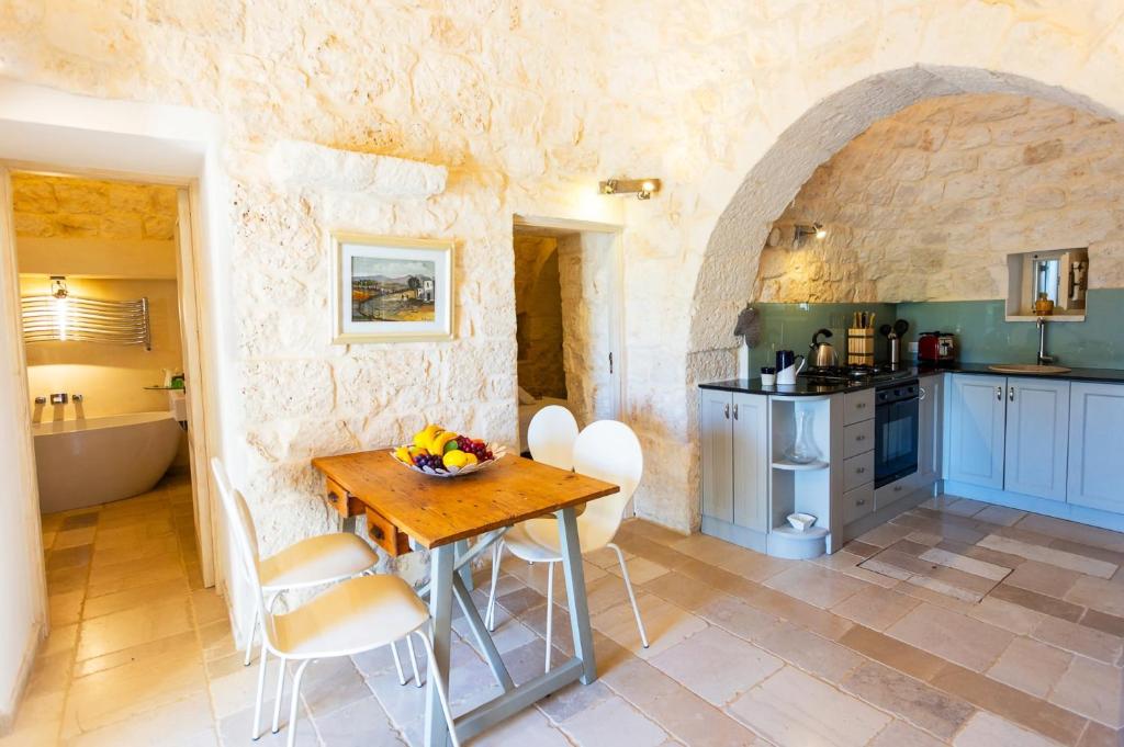- une cuisine avec une table en bois dans une chambre dans l'établissement Villa Trullo Selva Grande by Villa Plus, à Martina Franca