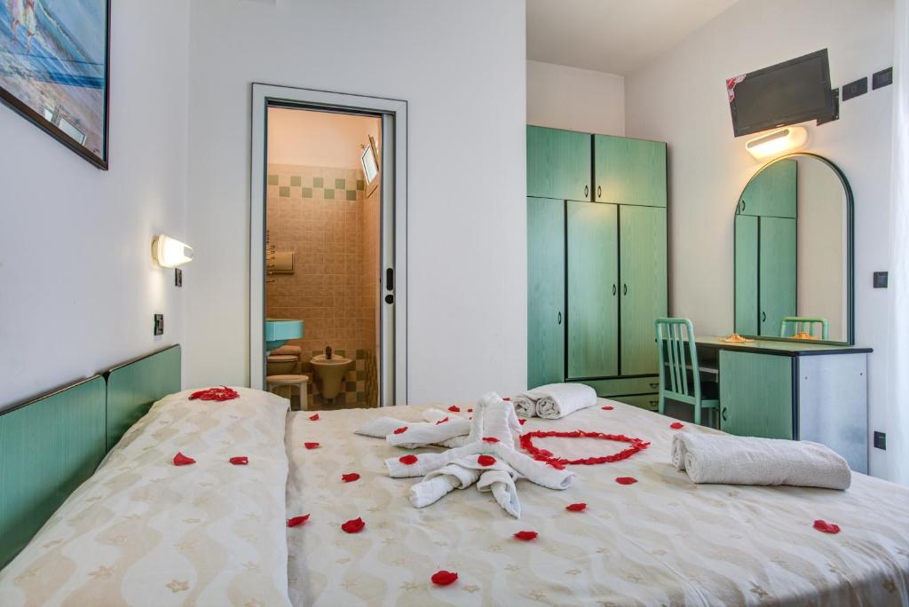 - une chambre avec un lit orné de roses rouges dans l'établissement Hotel San Paolo, à Rimini
