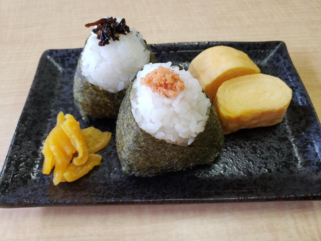 une assiette de sushis avec du riz et des fruits. dans l'établissement Hotel 螢月ｰhozukiｰ Adult Only, à Sendai