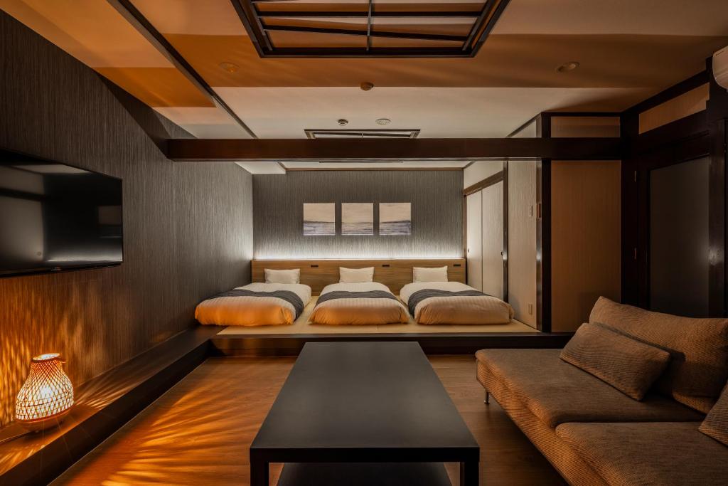 une chambre avec deux lits et un canapé dans l'établissement AWA Nishi-Izu, à Numazu