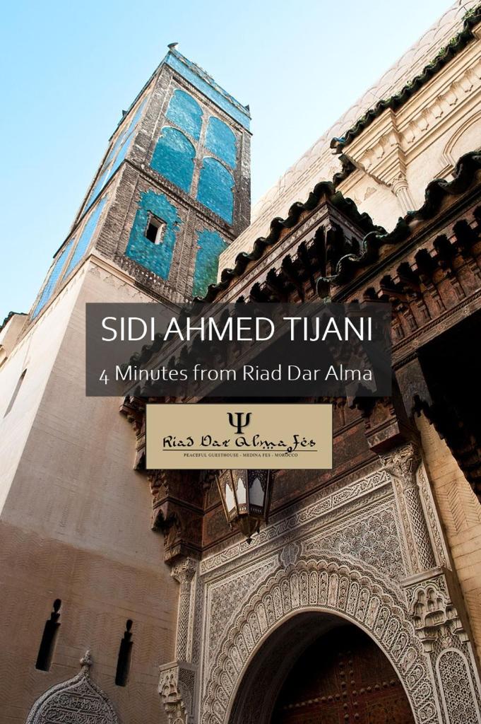 un panneau devant un bâtiment avec une tour dans l'établissement Riad Dar Alma Fes, à Fès