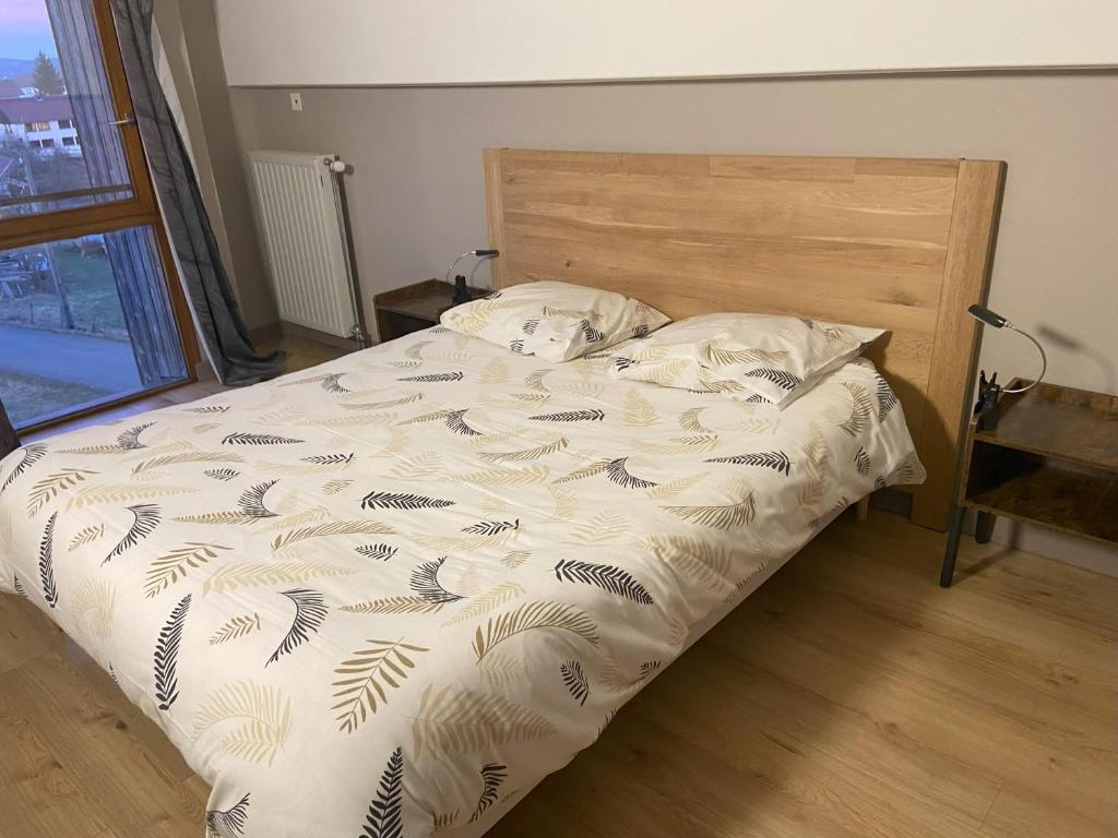 une chambre avec un lit avec une tête de lit en bois dans l'établissement Gîte comme à la maison -12 pers- La Cabiote, à Les Piards