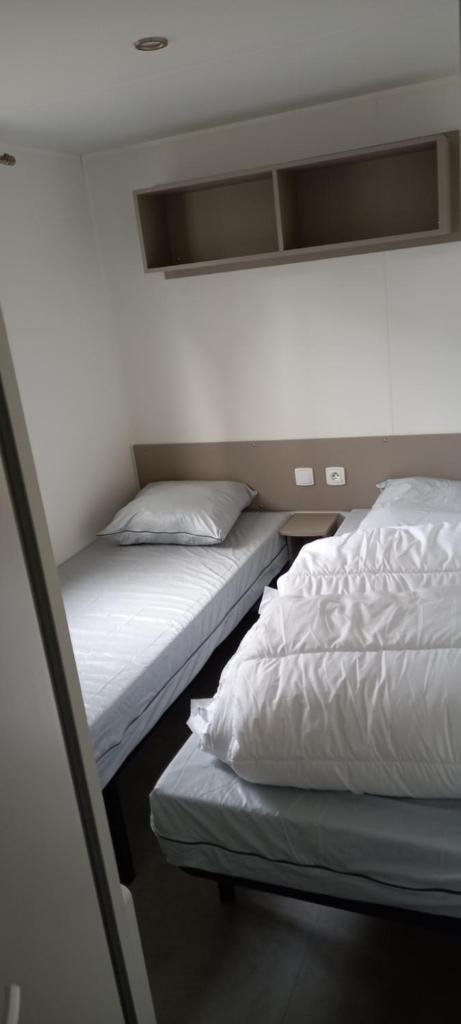 deux lits jumeaux dans une chambre avec dans l'établissement MH 3 chambres au coeur du camping Bois Dormant 90, à Saint-Jean-de-Monts