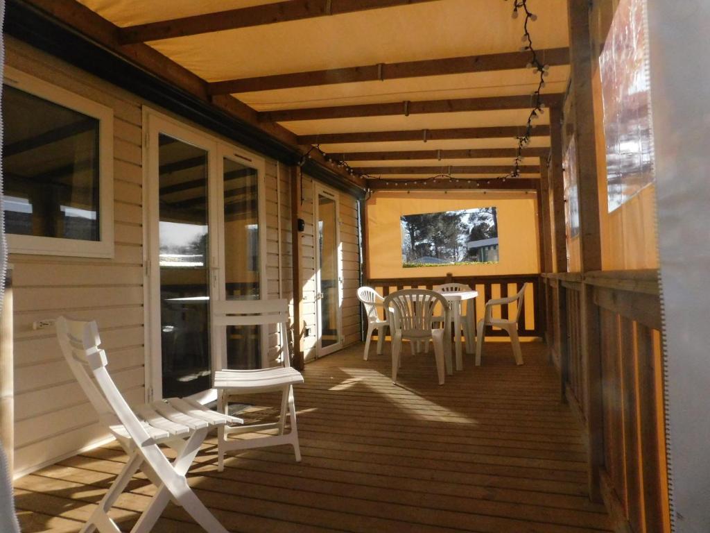 un porche d'une maison avec des chaises et une table dans l'établissement Domaine de Kerlann 4 étoiles - MOBIL HOME 2 CHAMBRES - 2 SDB - 315, à Pont-Aven