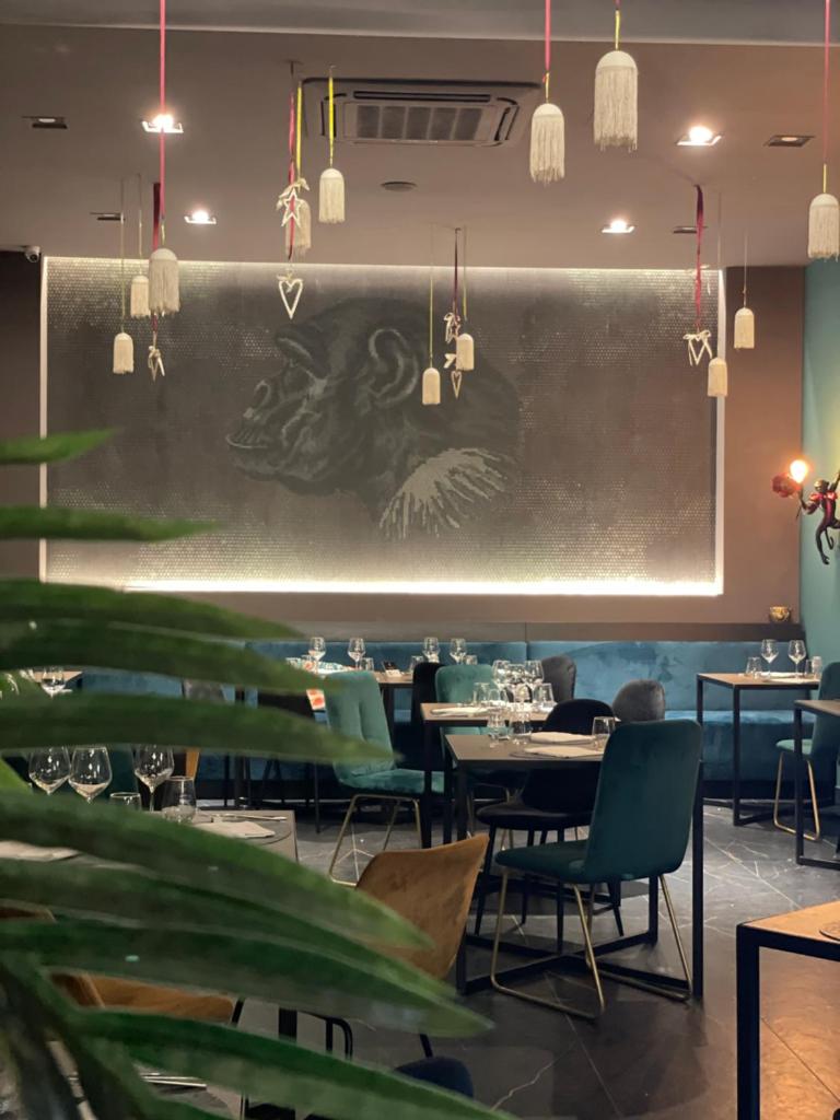 un restaurant avec des tables, des chaises et un tableau noir dans l'établissement Villa Achiropita, à Rossano