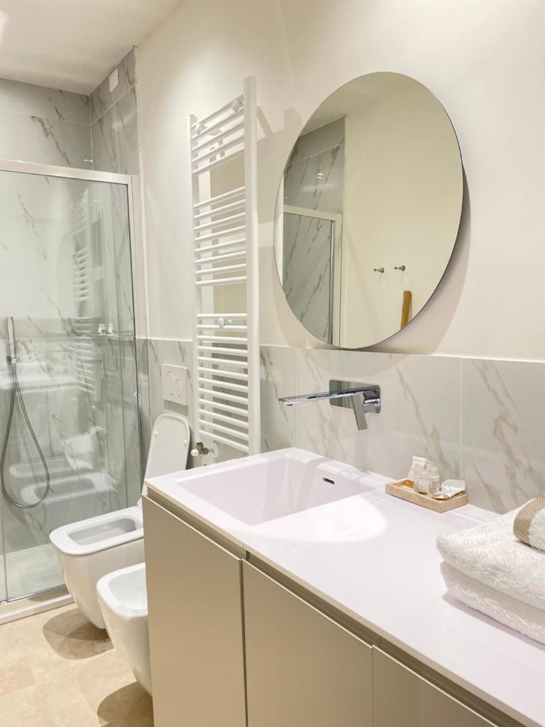 une salle de bain avec un lavabo, des toilettes et un miroir dans l'établissement Villa Achiropita, à Rossano