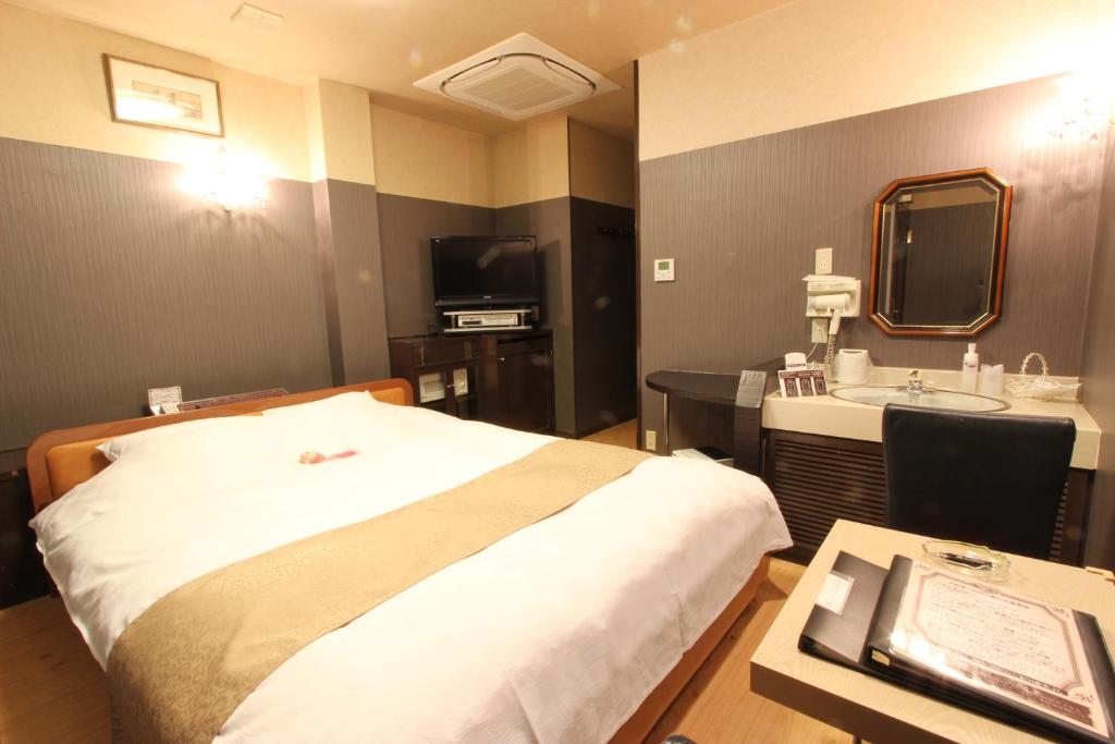 une chambre d'hôtel avec un lit et un lavabo dans l'établissement Hotel Mori no Komichi, à Fukuchiyama