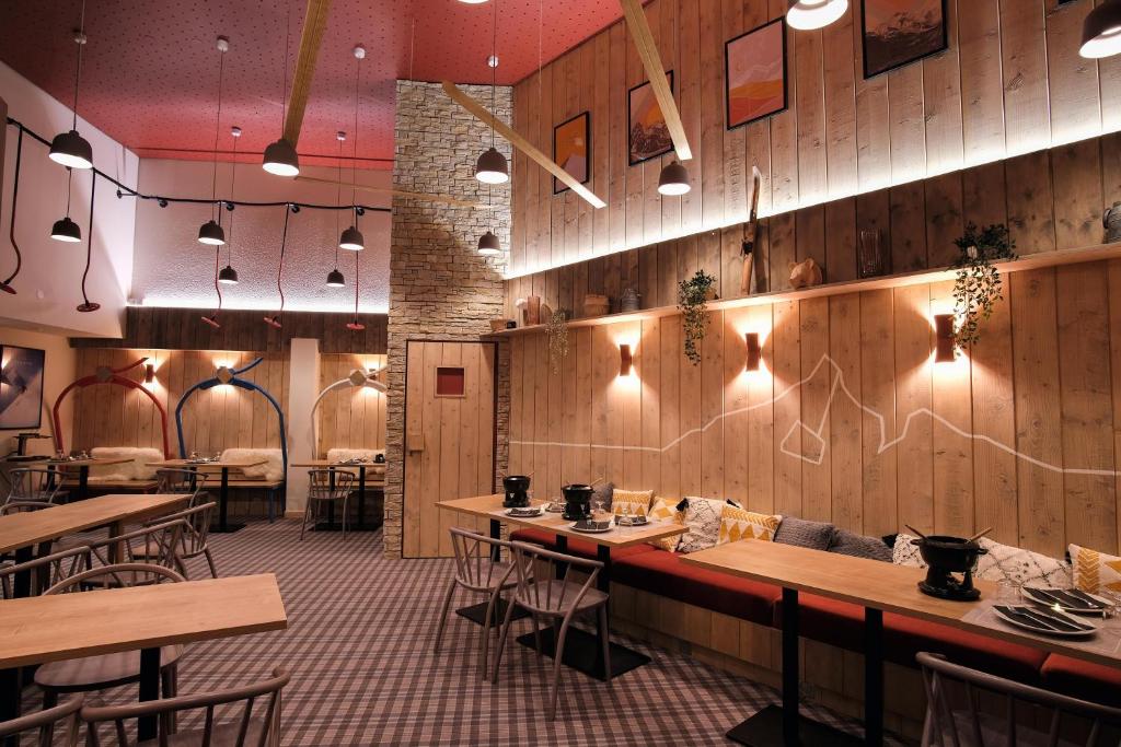 un restaurant avec des murs en bois, des tables et des chaises dans l'établissement Belambra Clubs Les Saisies - Les Embrunes - Ski pass included, à Villard-sur-Doron