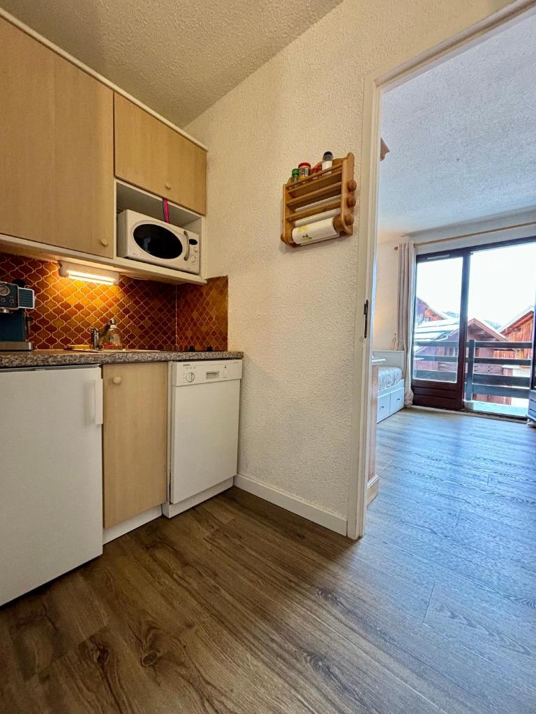 une cuisine avec un évier et un micro-ondes dans l'établissement L'ETERLOU, Studio Centre station, à Risoul