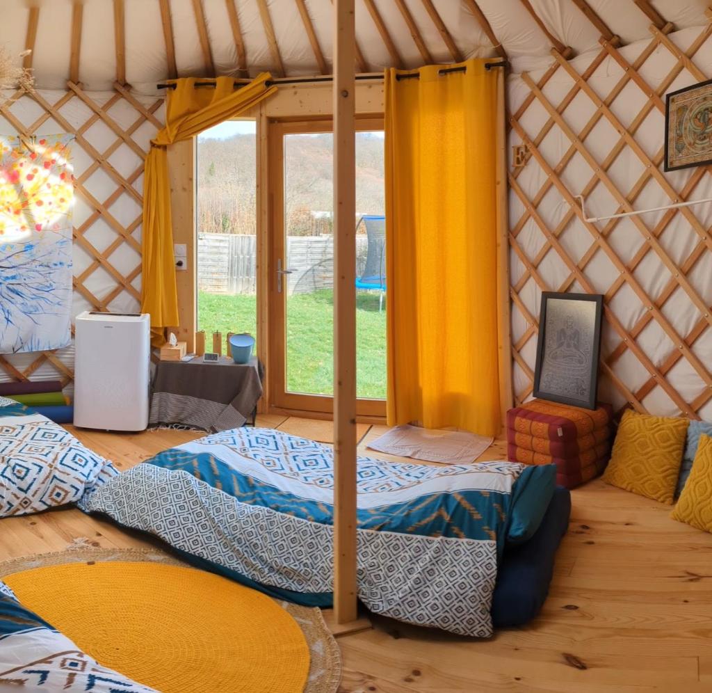 - une chambre avec un lit dans une yourte dans l'établissement Yourte atypique entre Lyon et Grenoble ! Vue sur les montagnes., à Nohant-en-Graçay