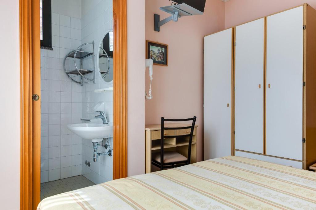 une chambre avec un lit et un lavabo dans l'établissement Hotel Sorriso, à Rimini
