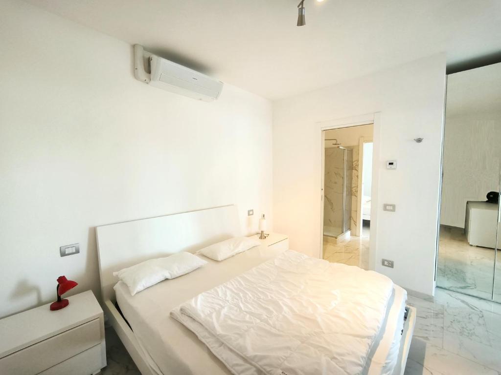 une chambre blanche avec un lit et un miroir dans l'établissement Casa Blanca, à Lesa 29 autres photos