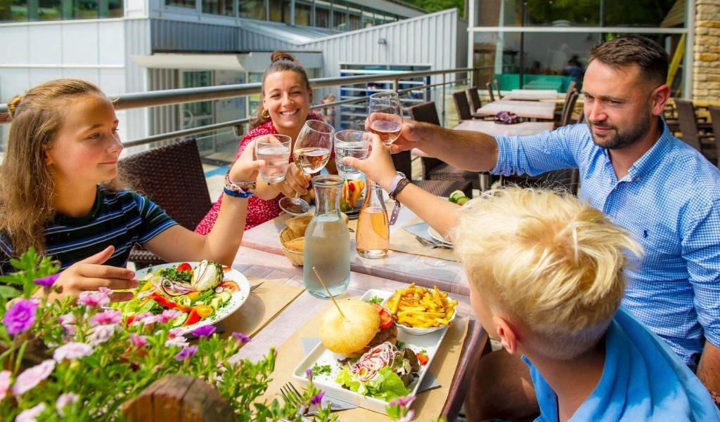 un groupe de personnes assises autour d'une table en train de boire du vin dans l'établissement Camping Le Ty Nadan - Roan, à Quimperlé