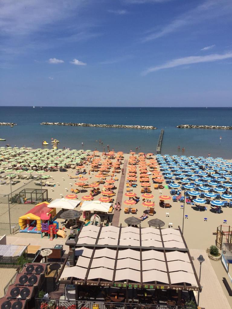 une plage remplie de nombreux parasols et de l'eau dans l'établissement Hotel Sandra, à Gatteo a Mare