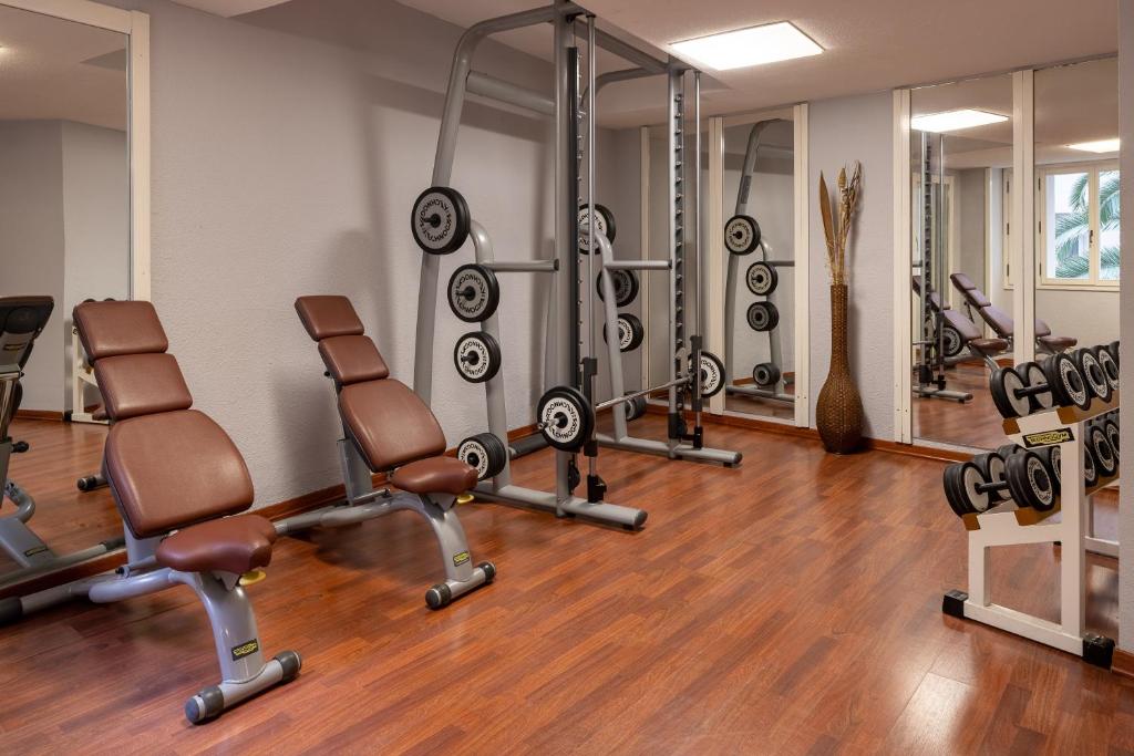 - une salle de sport avec des tapis de course et des chaises dans l'établissement UNA Hotels Capotaormina, à Taormine