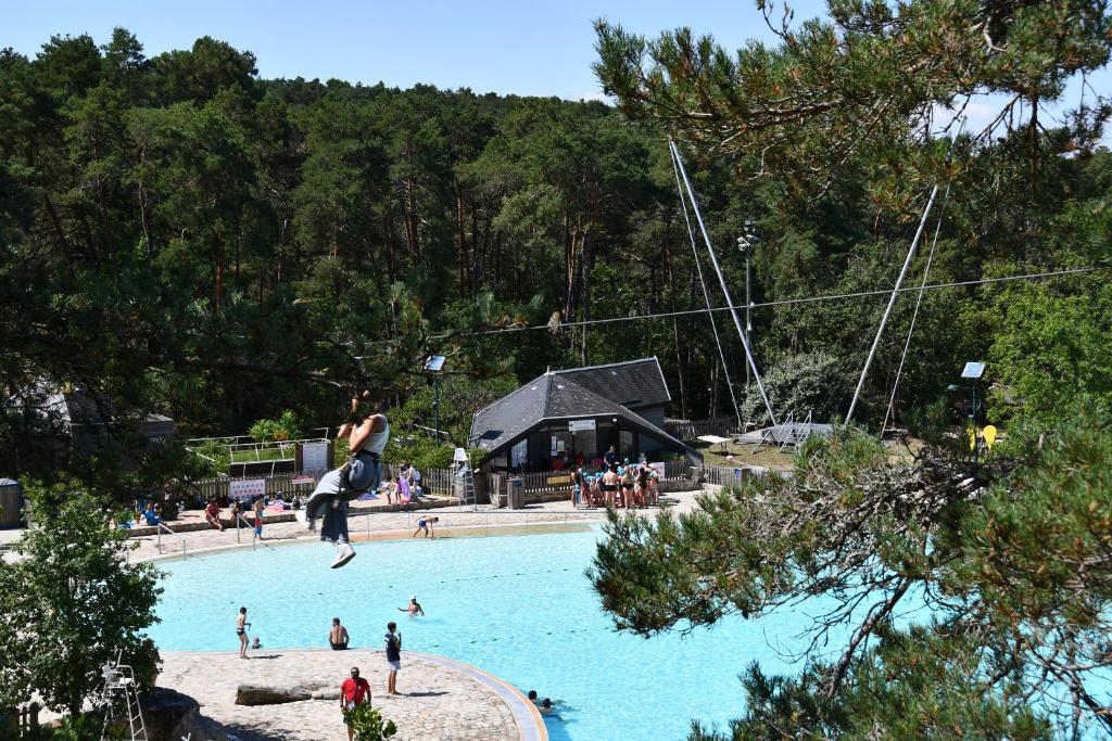 un groupe de personnes dans une grande piscine dans l'établissement Mobil home ile de loisirs de buthiers, à Buthiers