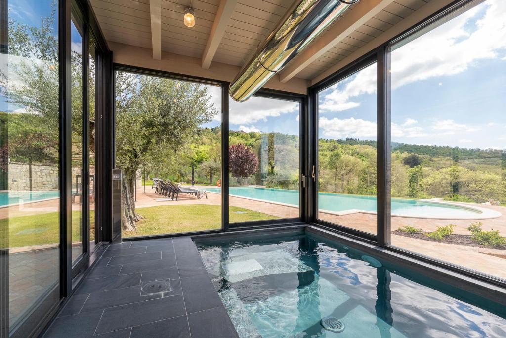 - une piscine intérieure dans une maison dotée de grandes fenêtres dans l'établissement Luxury Estate Villa Trasimena Lake, à Magione 39 autres photos