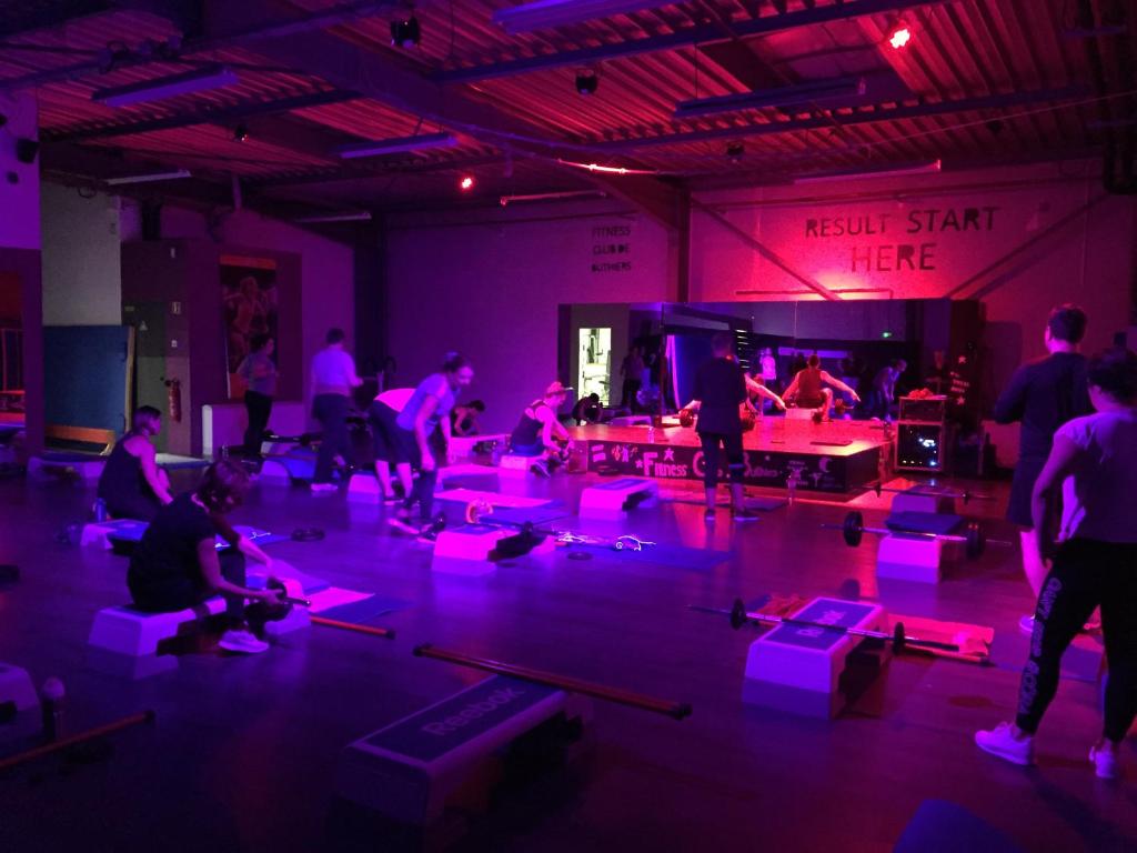 - un groupe de personnes dans une pièce avec des lumières violettes dans l'établissement Mobil home ile de loisirs de buthiers, à Buthiers