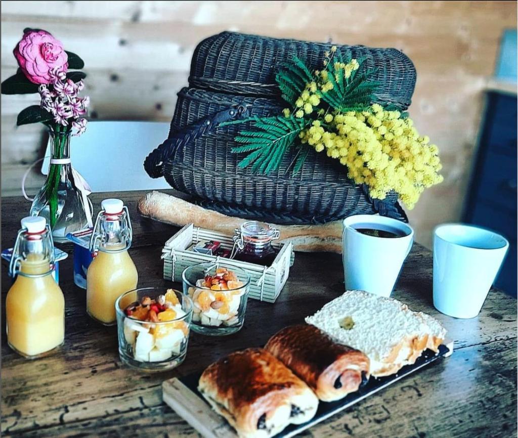 une table avec des aliments et des boissons pour le petit-déjeuner dans l'établissement La roulotte de Fichous, à Fichous-Riumayou
