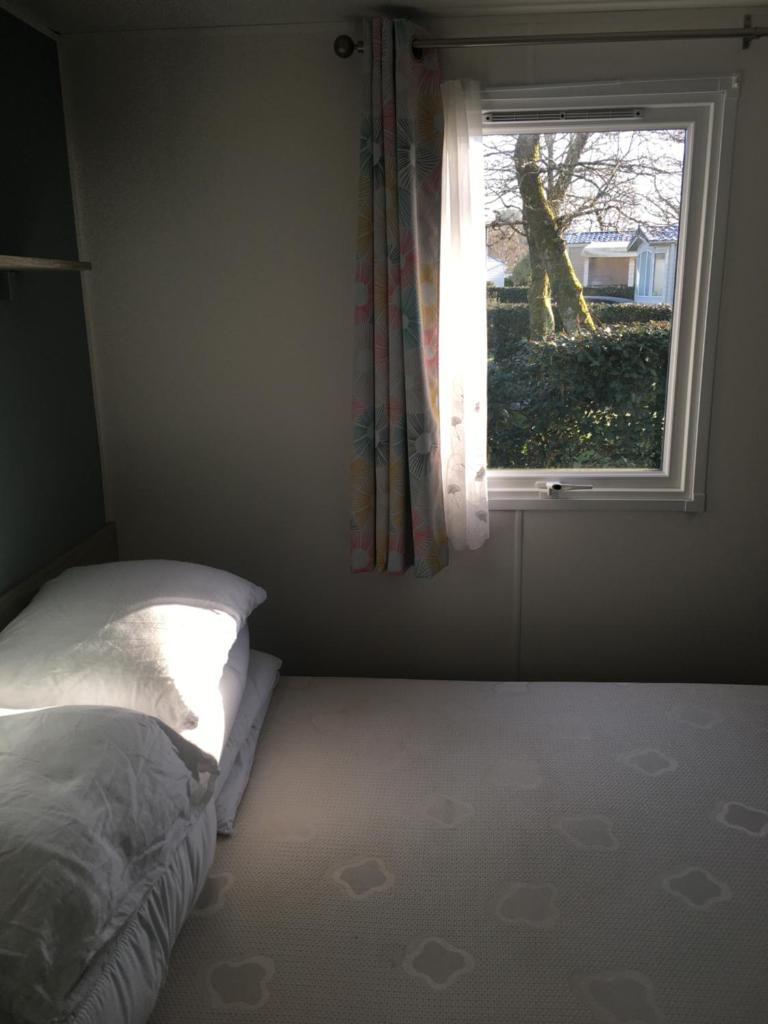 une chambre avec un lit et une fenêtre dans l'établissement domaine de Kerlann, à Pont-Aven