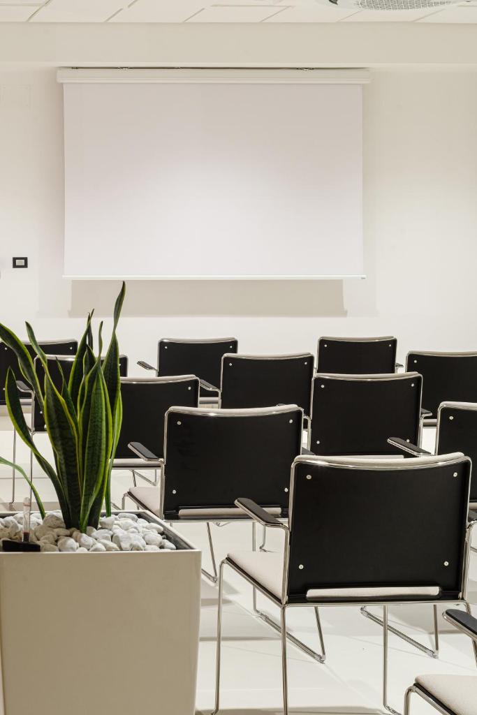 une pièce vide avec des chaises et une plante en pot dans l'établissement Grand Hotel Santa Maria, à Santa Maria di Castellabate