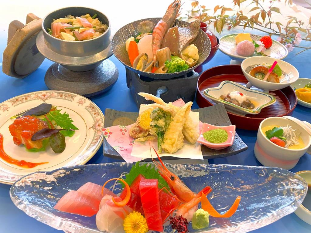 une table bleue avec des assiettes de nourriture dans l'établissement Hotel Nagisaya, à Katsuura 15 autres photos