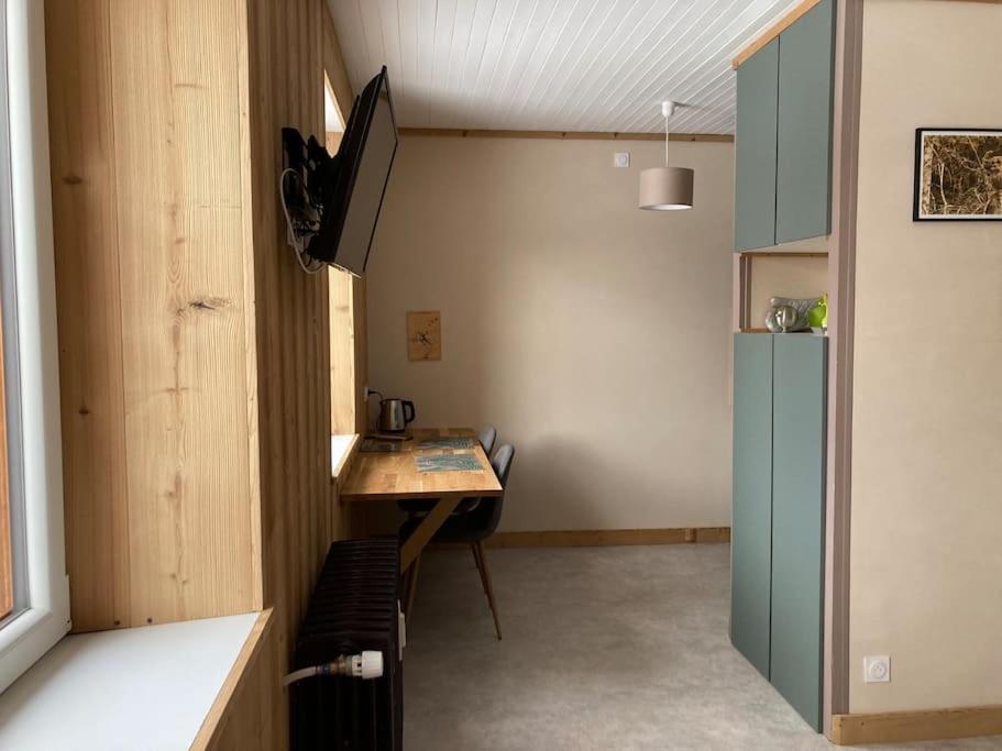 une petite cuisine avec une table et un réfrigérateur dans l'établissement Studio chaleureux au départ des sentiers et pistes de ski, à Lajoux