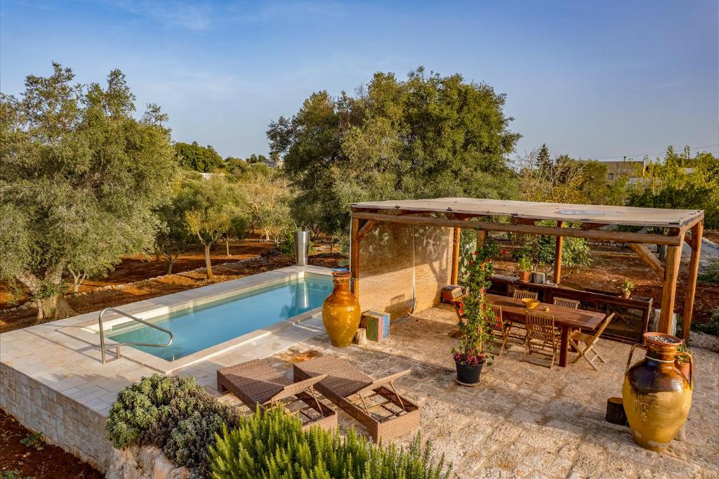 - une piscine avec une table de pique-nique et un pavillon dans l'établissement Trulli Magalò, à Ceglie Messapica